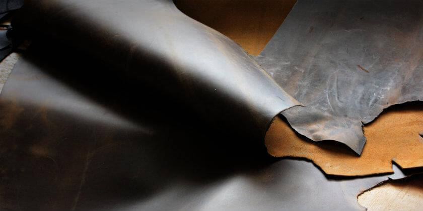 Folded high-quality leather sheets in dark brown tones, highlighting texture and craftsmanship