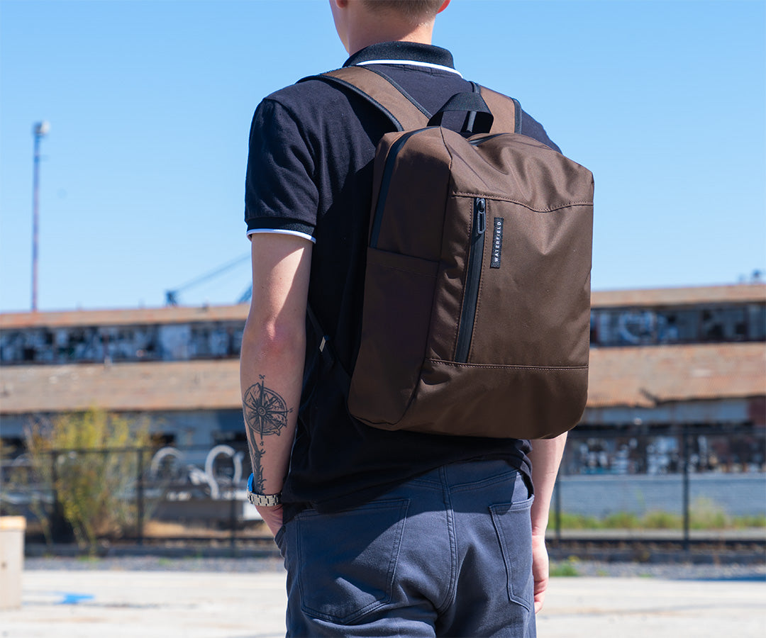 Person wearing brown Packable Backpack outdoors with urban background