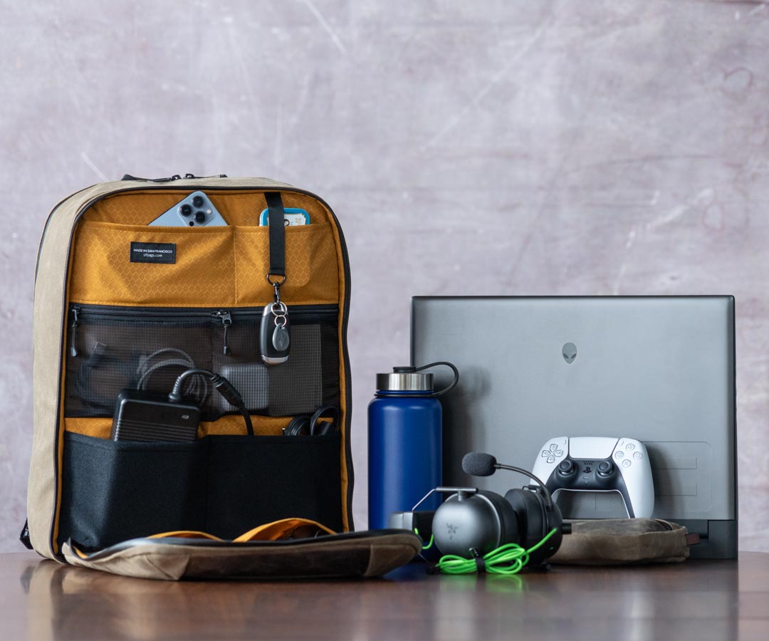 Tech Folio Tank backpack open with gadgets, laptop, and accessories displayed
