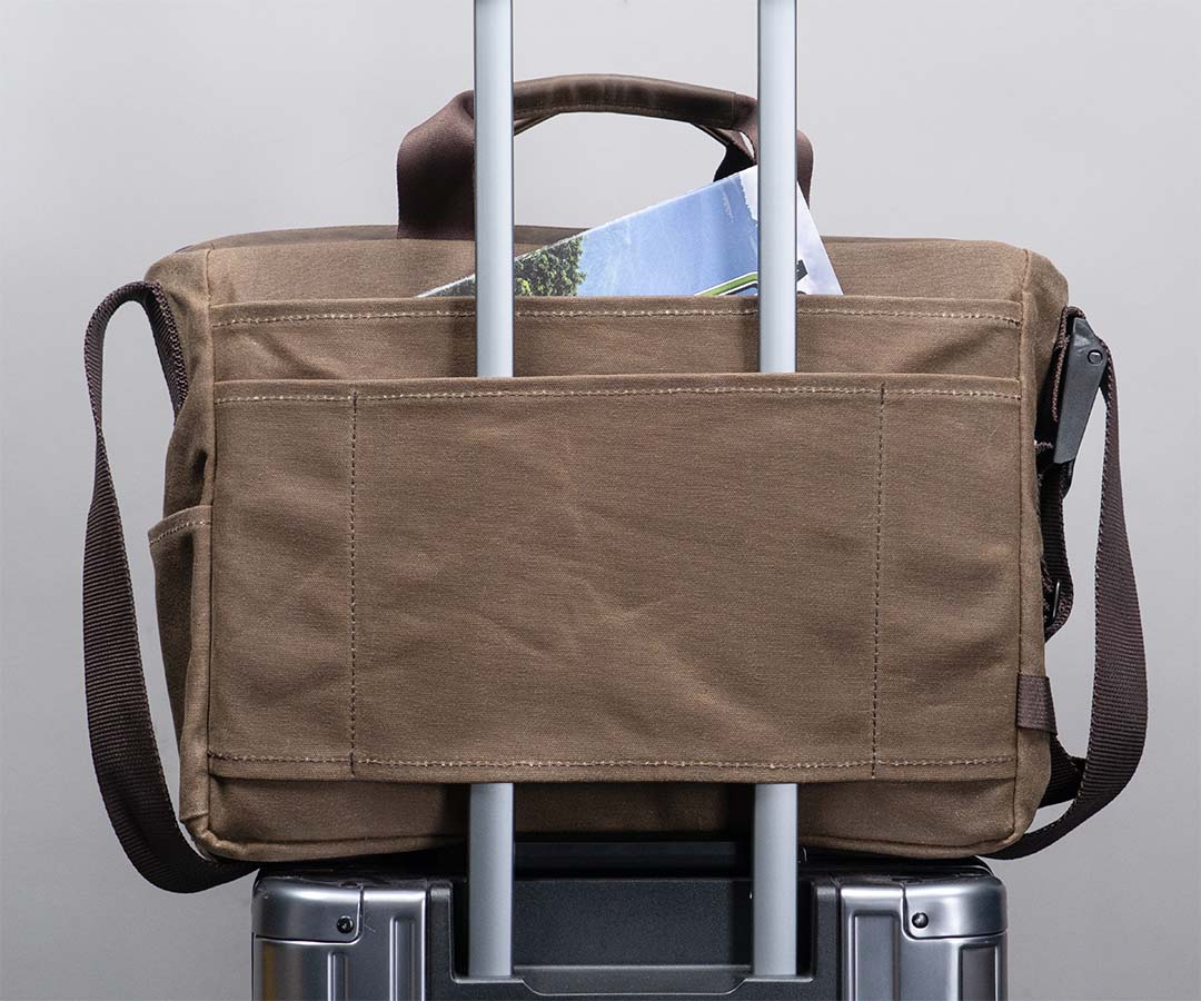 Slot-through pocket fits carry-on luggage handles
