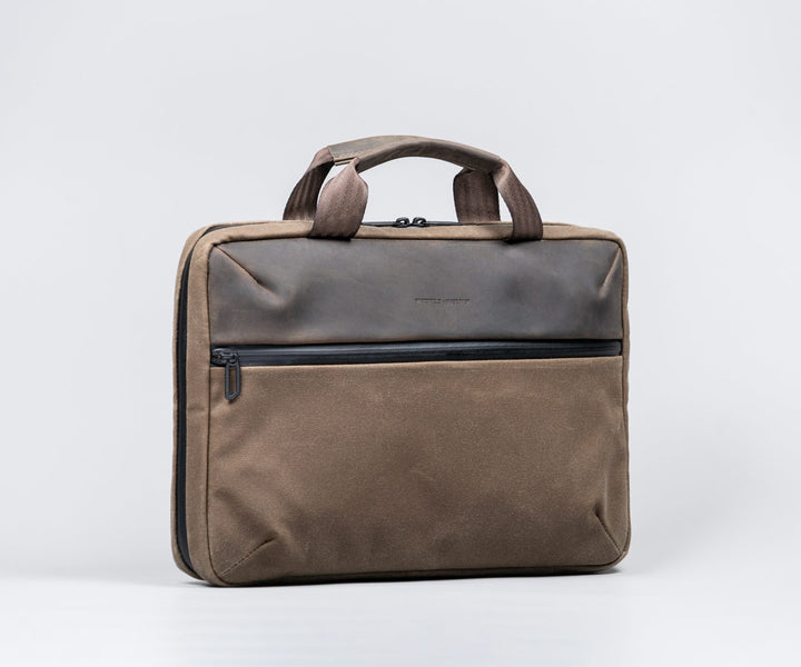 Front: full-grain leather panel + leather-wrapped handles.