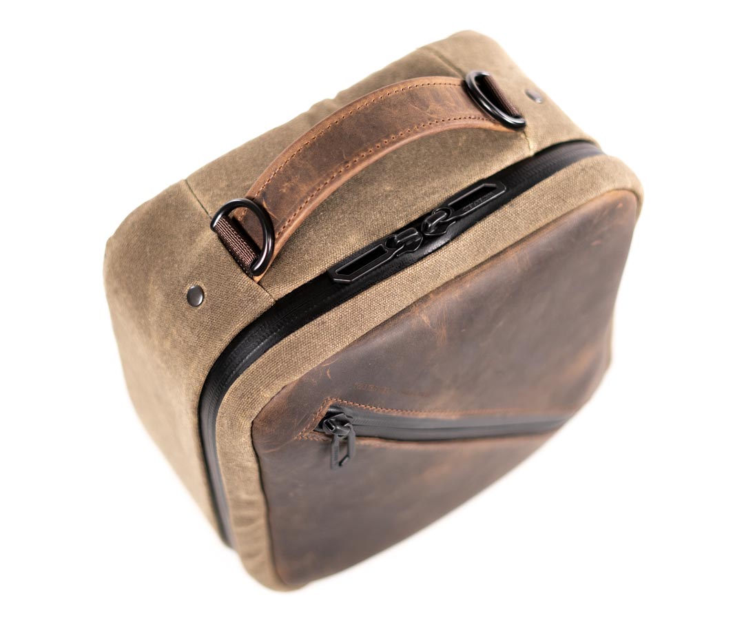 Sturdy full-grain leather handle is riveted to the case.